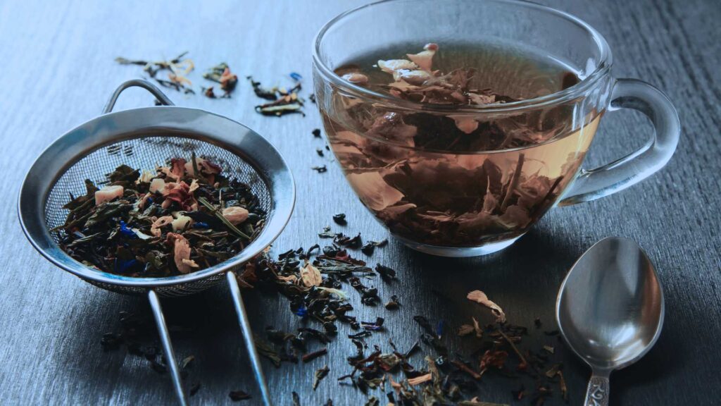 A tea cup with loose leaf tea sits on a table. This is the feature image for the creating calm app, that provides mental clarity for high achievers
