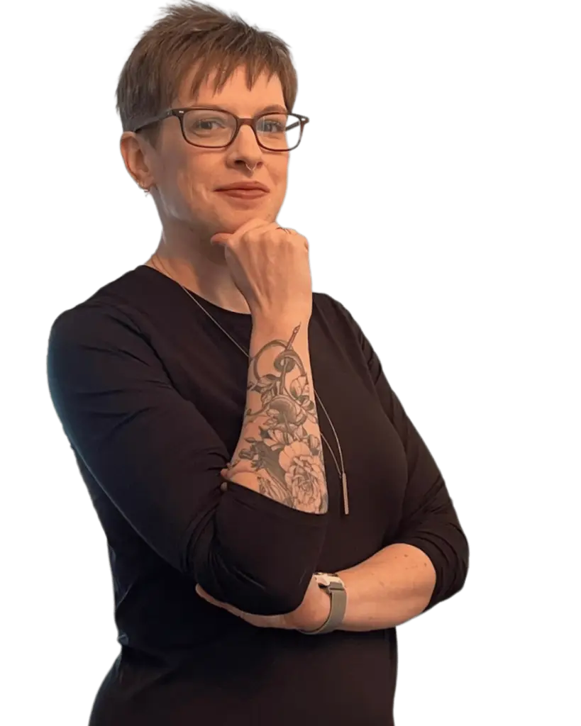 Stress management for high achievers expert Avery Thatcher standing in a black long sleeved shirt with a warm smile and direct eye contact